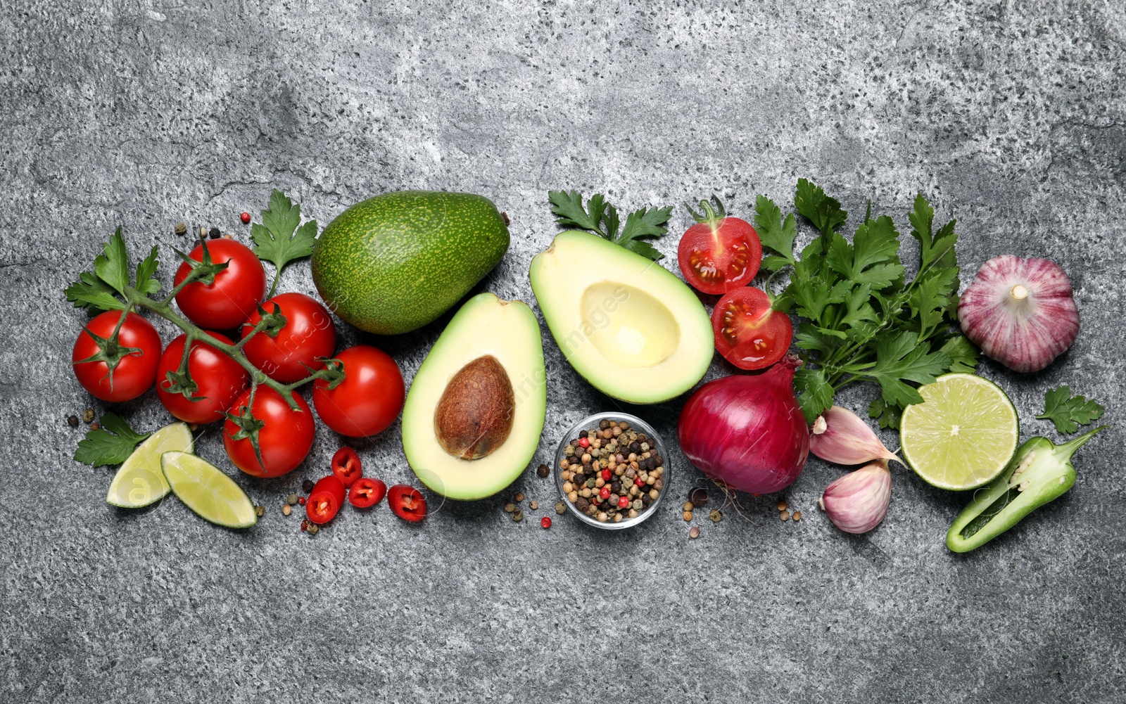 Photo of Fresh ingredients for guacamole on grey table, flat lay