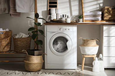 Stylish bathroom interior with modern washing machine