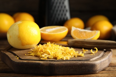 Photo of Lemon zest and fresh fruits on wooden table, closeup