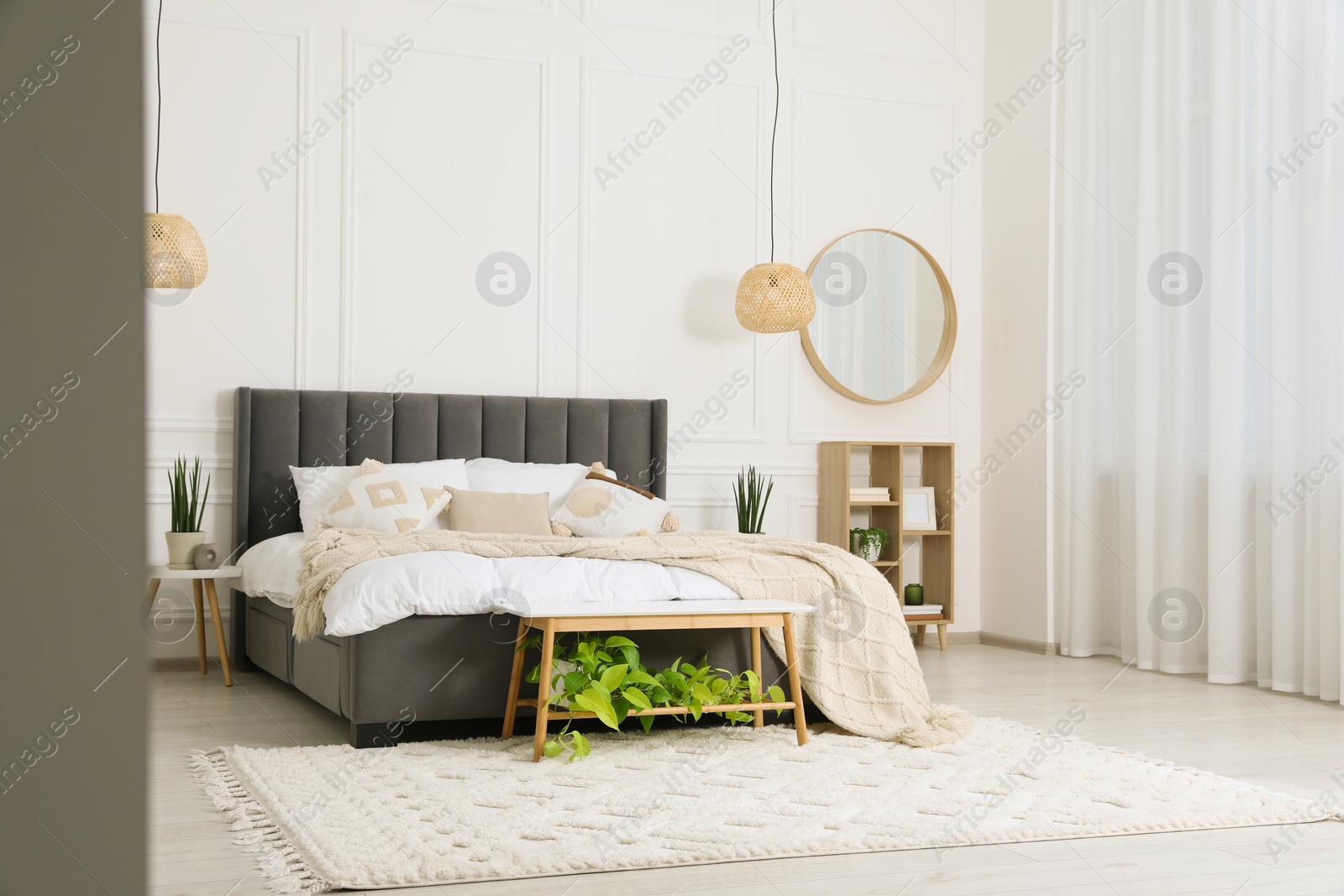 Photo of Stylish bedroom interior with large comfortable bed and mirror