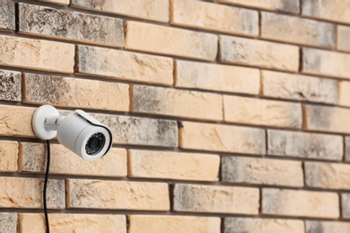 Modern security CCTV camera on brick wall