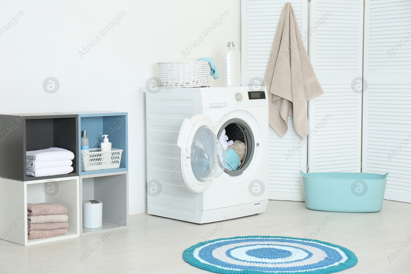 Photo of Crumpled towels in washing machine at home. Laundry room interior