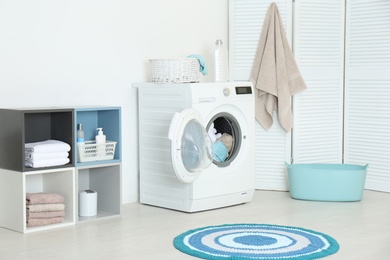 Crumpled towels in washing machine at home. Laundry room interior