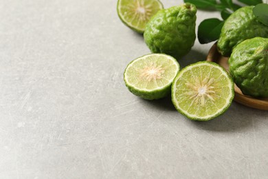 Photo of Fresh ripe bergamot fruits on light grey table, space for text