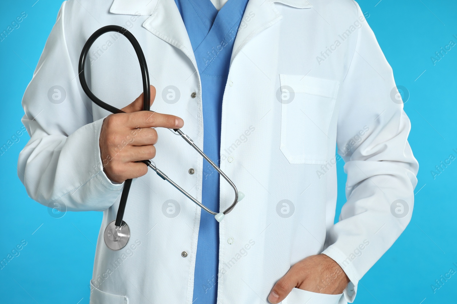 Photo of Doctor with stethoscope on blue background, closeup