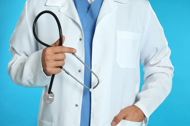 Photo of Doctor with stethoscope on blue background, closeup