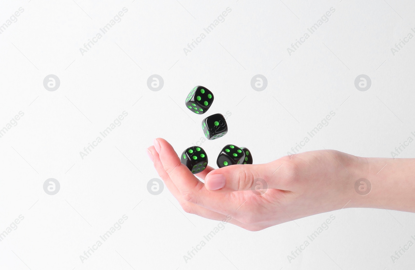 Photo of Woman throwing game dices on white background, closeup