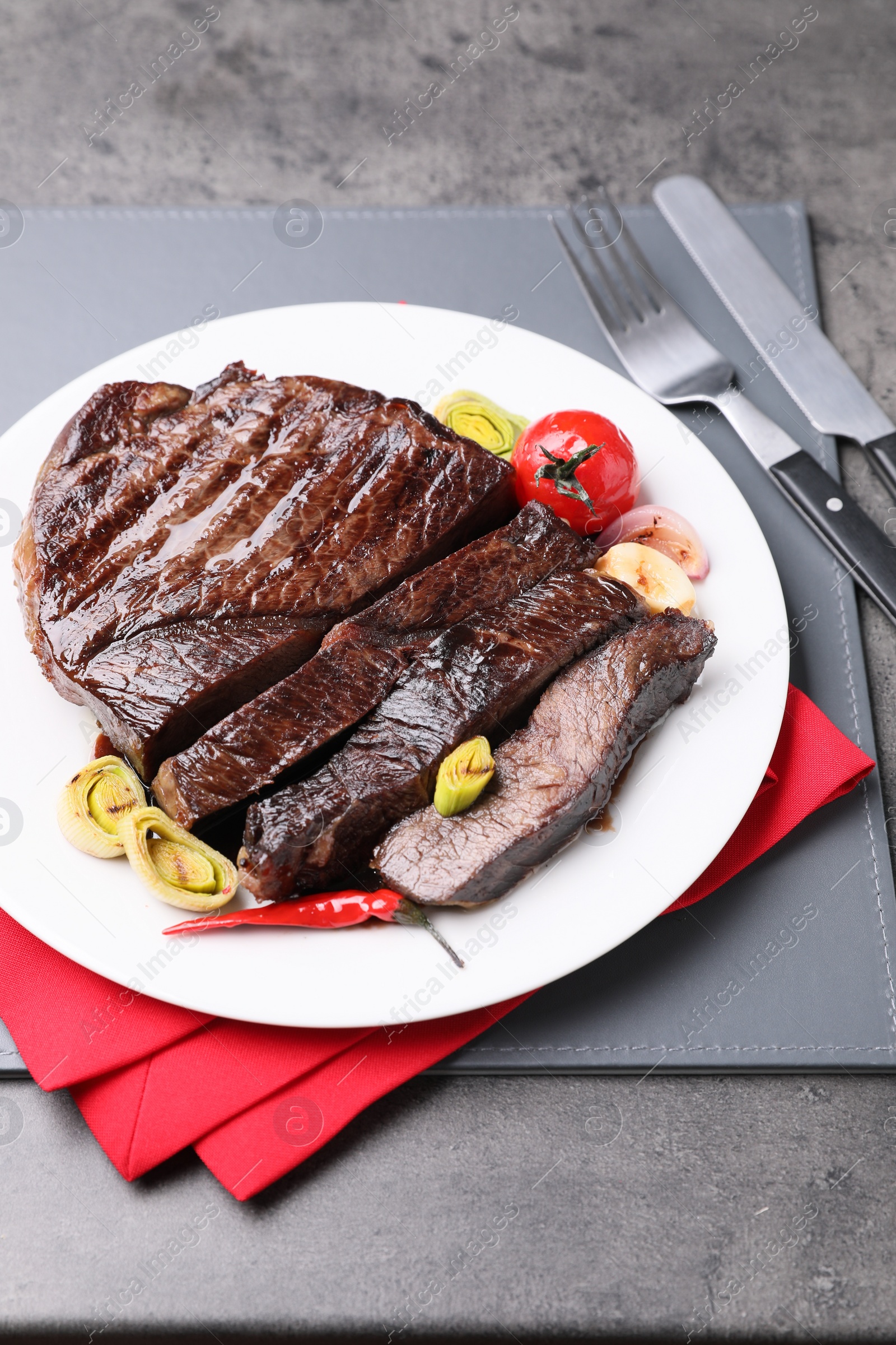 Photo of Delicious grilled beef meat served on grey table