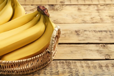 Ripe yellow bananas on wooden table. Space for text