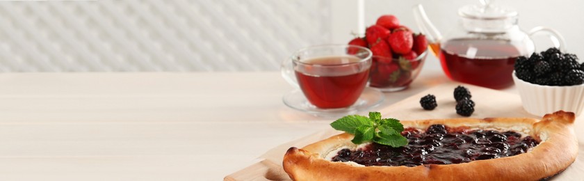 Image of Delicious sweet cottage cheese pastry with jam served on white wooden table, banner design. Space for text