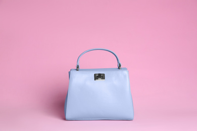 Photo of Stylish woman's bag on light pink background