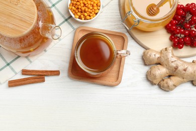 Immunity boosting tea with ingredients on white wooden table