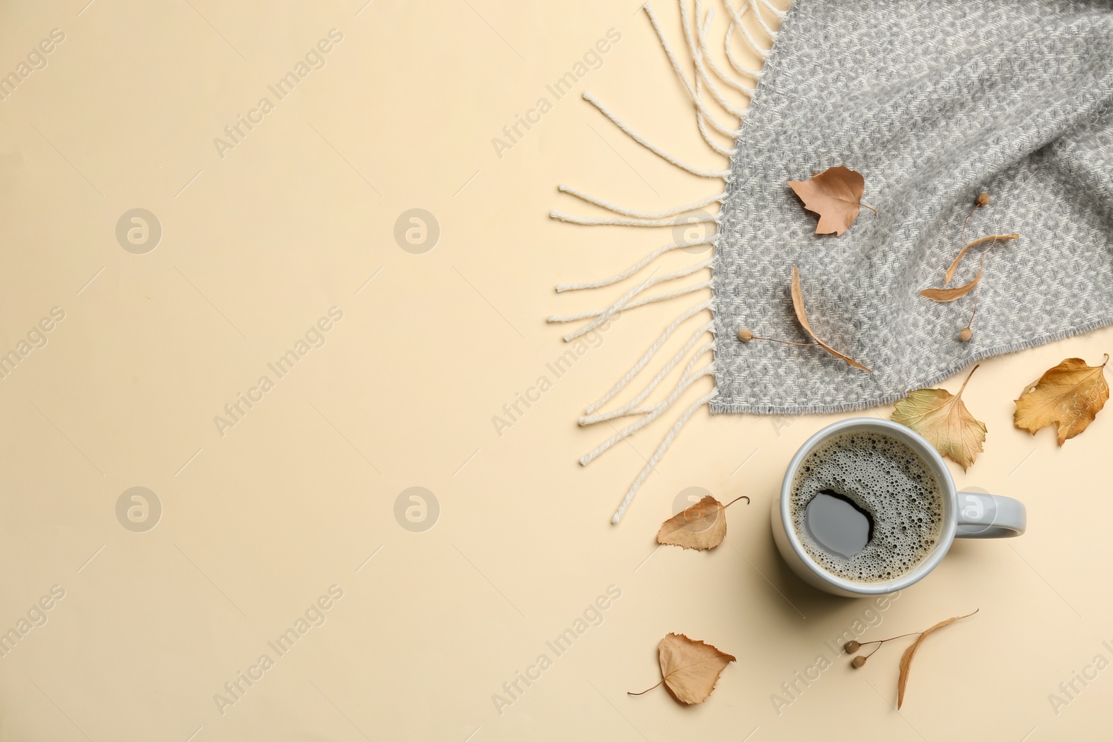 Photo of Flat lay composition with hot drink and warm plaid on beige background, space for text
