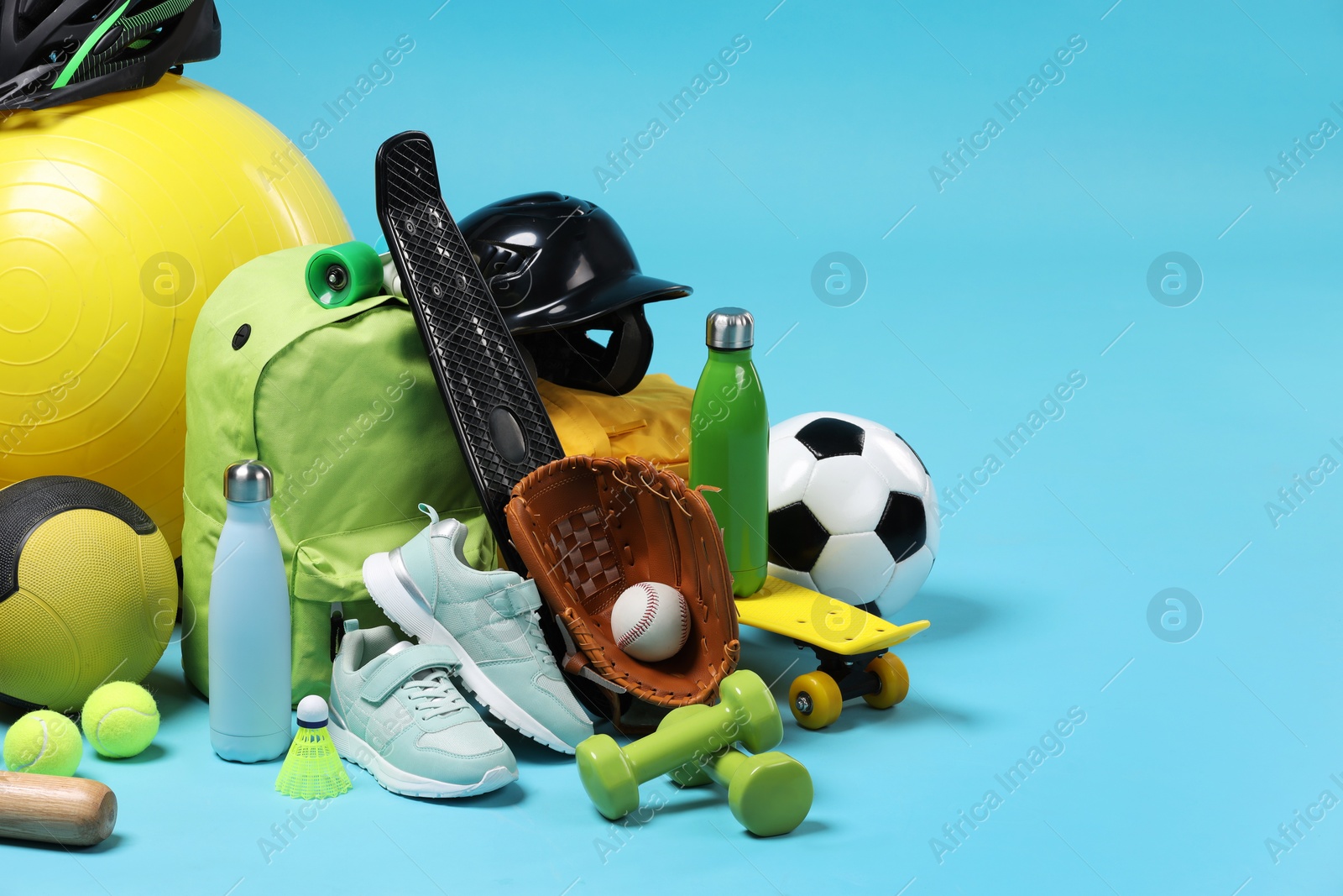 Photo of Many different sports equipment on light blue background, space for text
