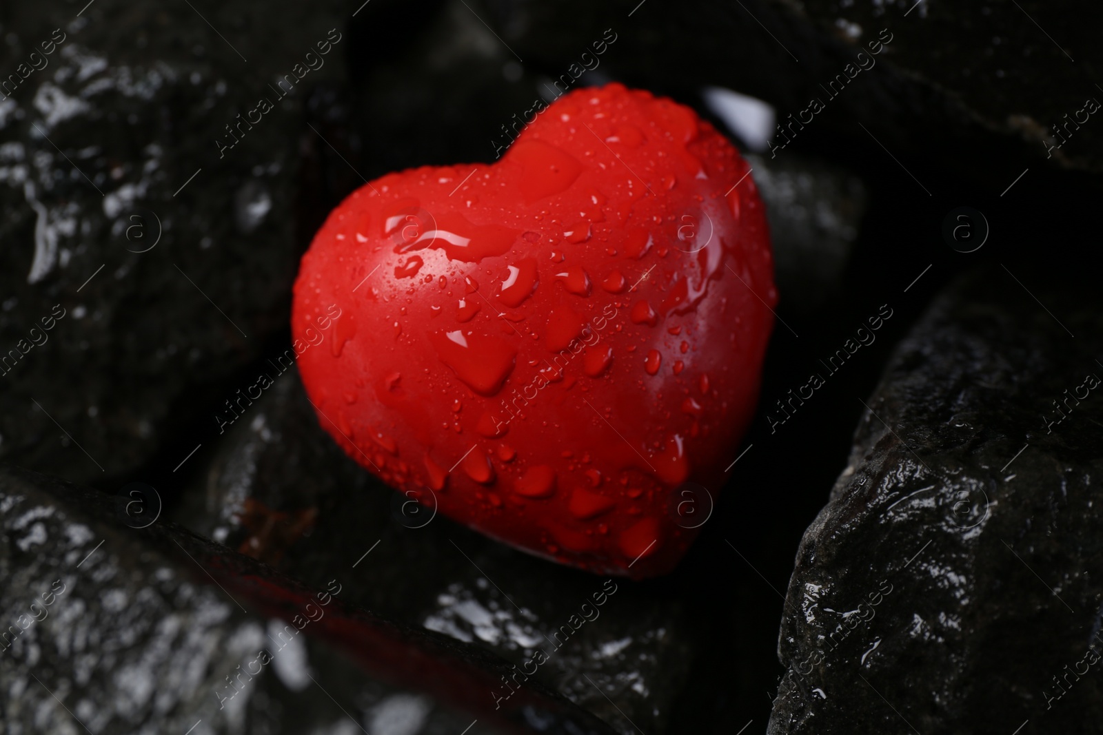 Photo of Red decorative heart on stones, closeup view