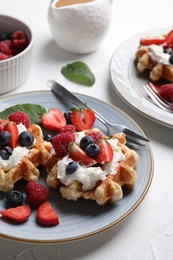 Delicious Belgian waffles with fresh berries and whipped cream on white table