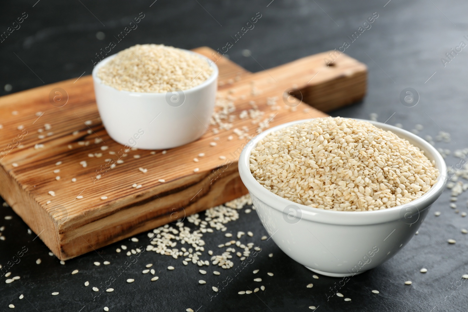 Photo of White sesame seeds on black slate table