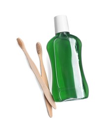Photo of Fresh mouthwash in bottle and toothbrushes isolated on white, top view
