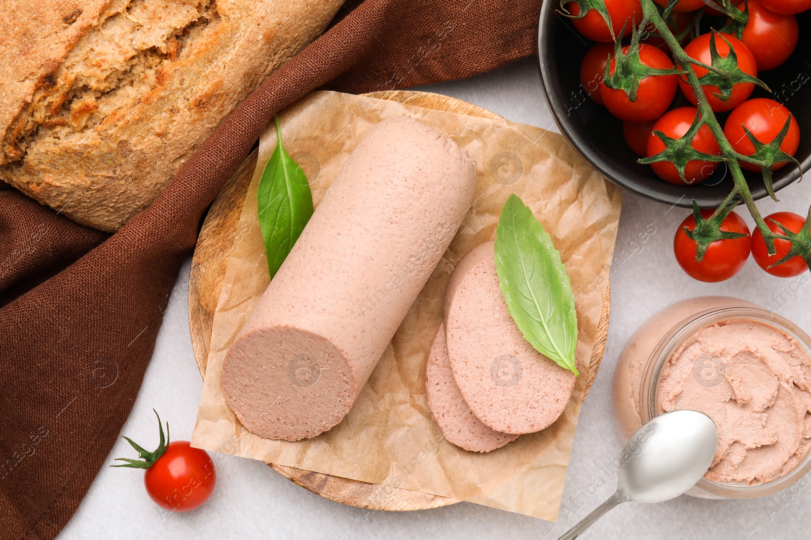 Photo of Delicious liver sausages, paste and cherry tomatoes on light grey table, flat lay