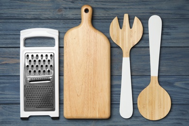 Photo of Set of modern cooking utensils on blue wooden table, flat lay
