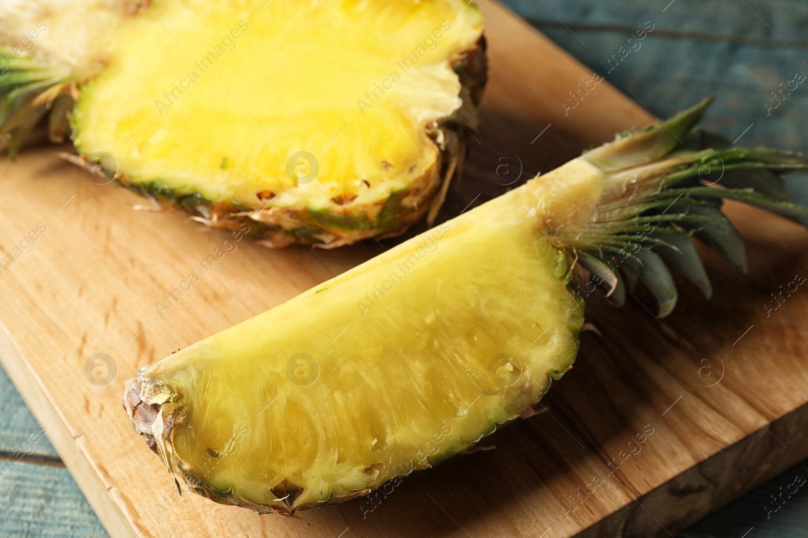 Photo of Cut fresh juicy pineapple on wooden board, closeup