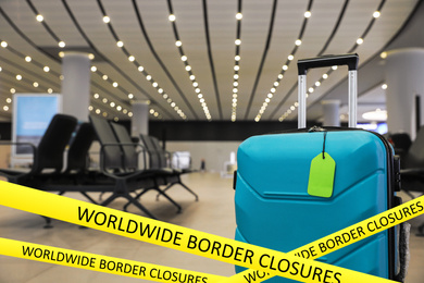 Image of Worldwide border closures through quarantine during coronavirus outbreak. Suitcase in airport and yellow awareness ribbons 