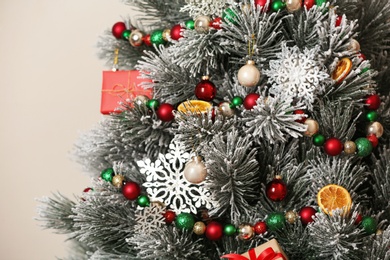 Photo of Beautiful Christmas tree with decor against light background, closeup