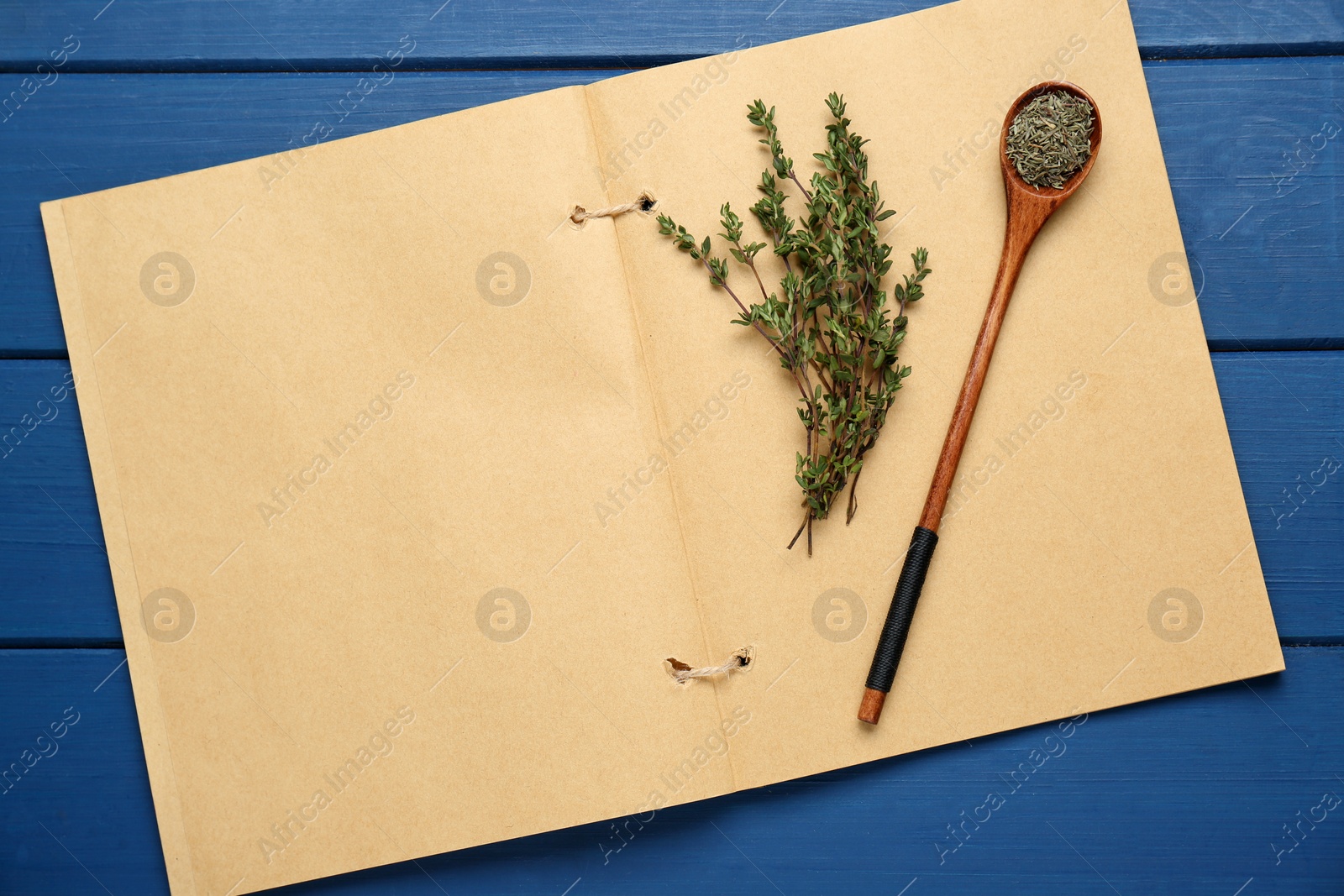 Photo of Blank recipe book and thyme on blue wooden table, top view. Space for text