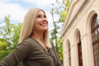 Portrait of beautiful woman on city street, space for text