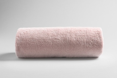 Photo of Fresh soft rolled towel on light background