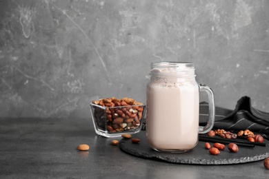 Photo of Mason jar with delicious milk shake on table