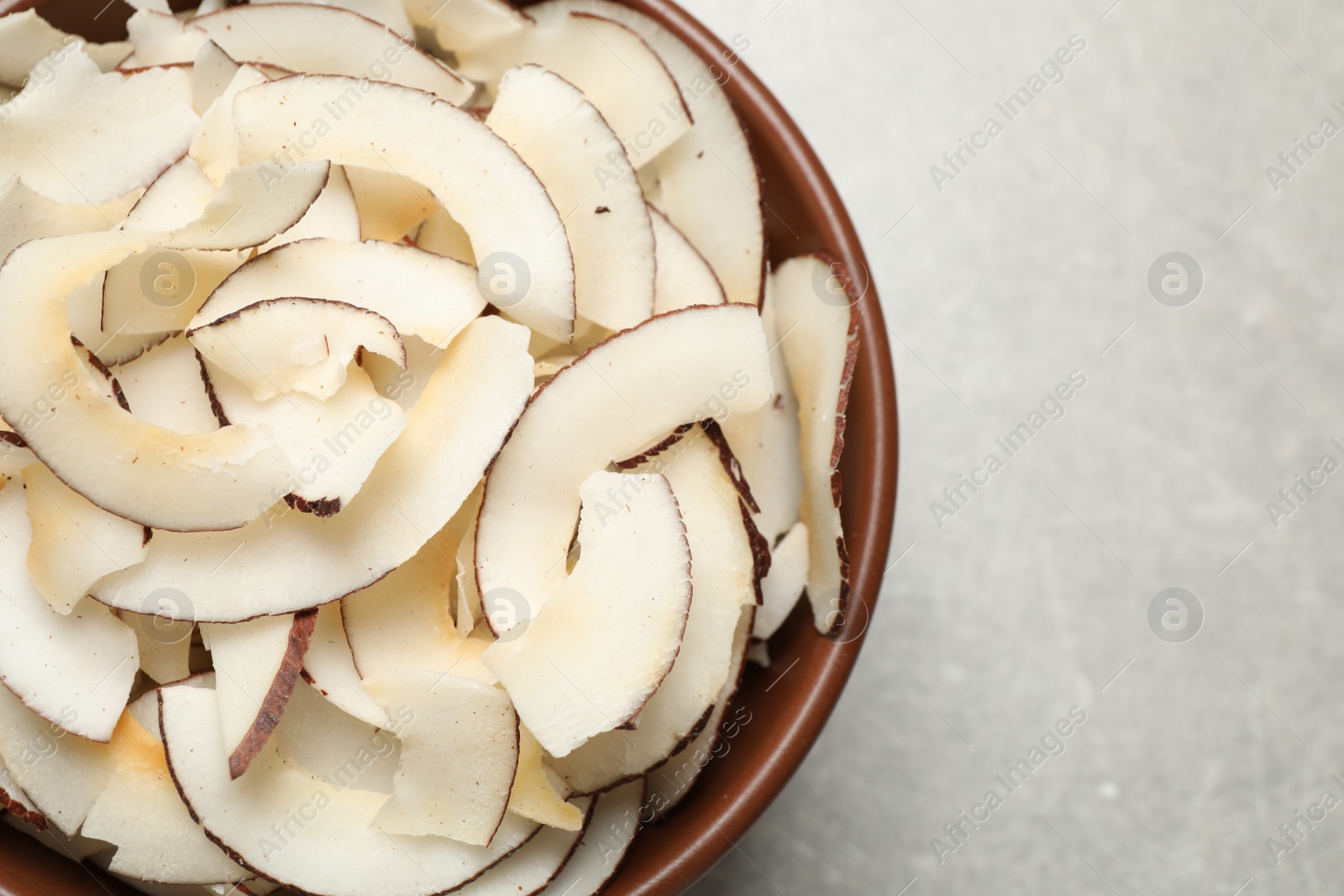 Photo of Tasty coconut chips on grey background, top view