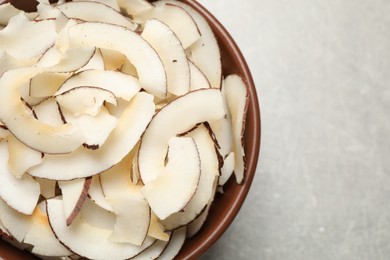 Tasty coconut chips on grey background, top view