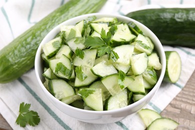 Delicious cucumber salad in bowl on table, closeup