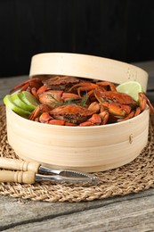 Photo of Delicious boiled crabs with lime and dill served on wooden table