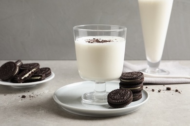 Photo of Glass with milk and chocolate cookies on table against grey background