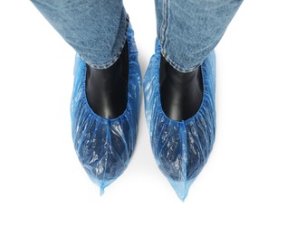 Photo of Woman wearing blue shoe covers onto her boots against white background, top view