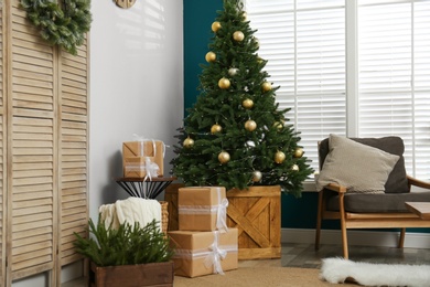 Photo of Beautiful decorated Christmas tree in living room interior