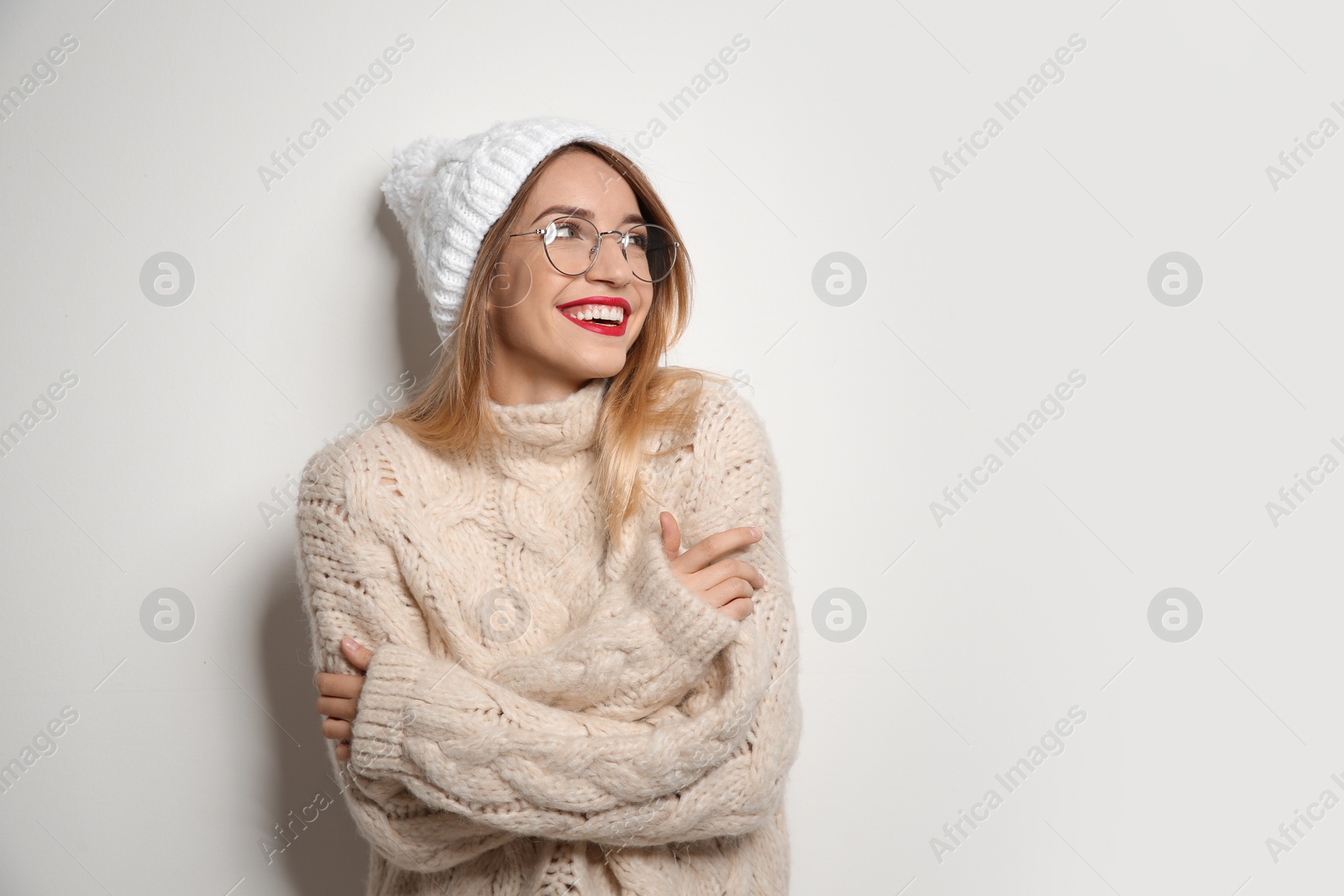 Photo of Beautiful young woman in warm sweater with hat on white background. Space for text