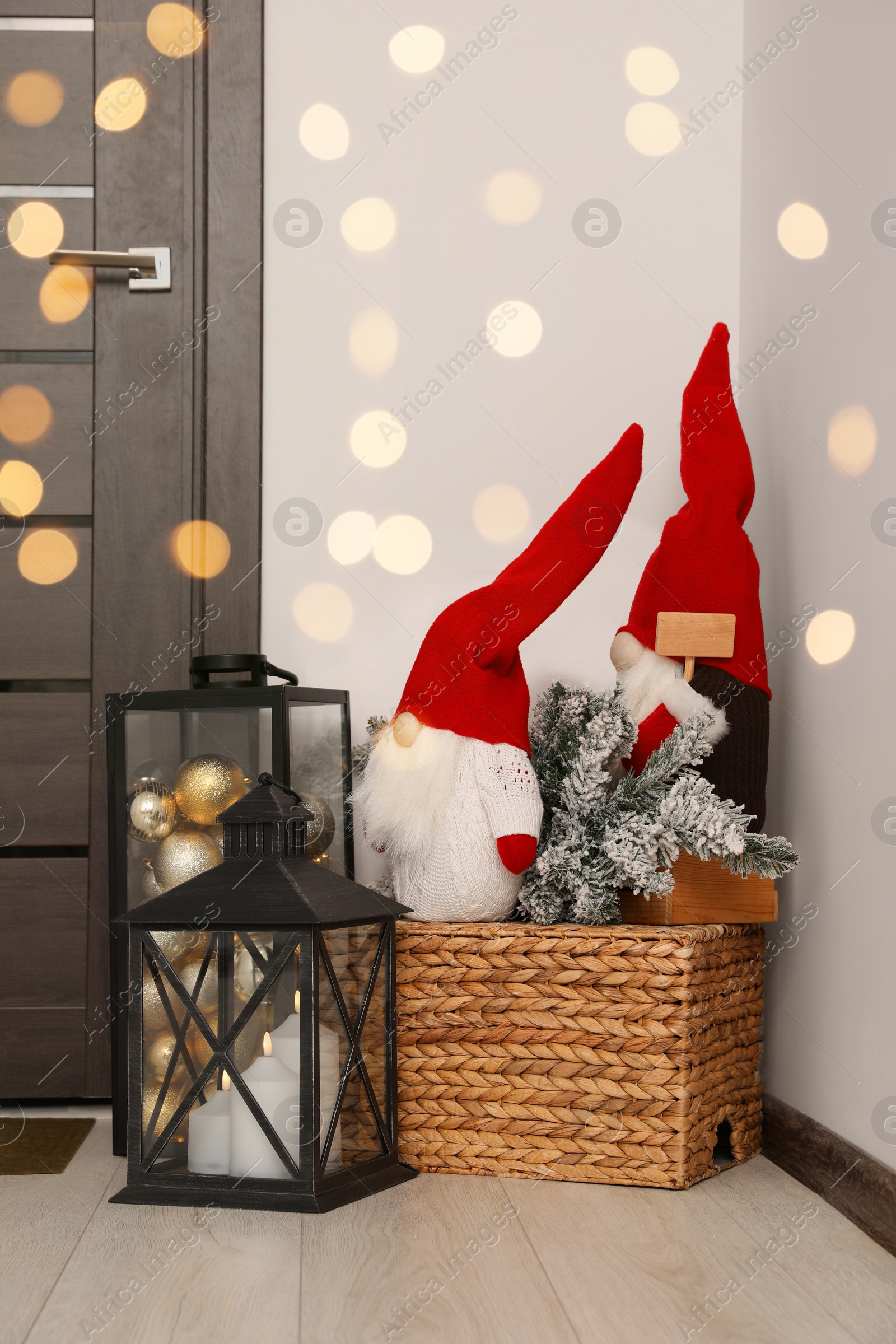 Photo of Christmas gnomes, lanterns with candles and balls indoors