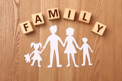 Photo of Paper cutout and word Family made of wooden cubes with letters on table, flat lay