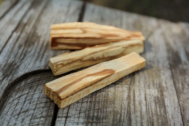 Palo santo sticks on wooden table outdoors