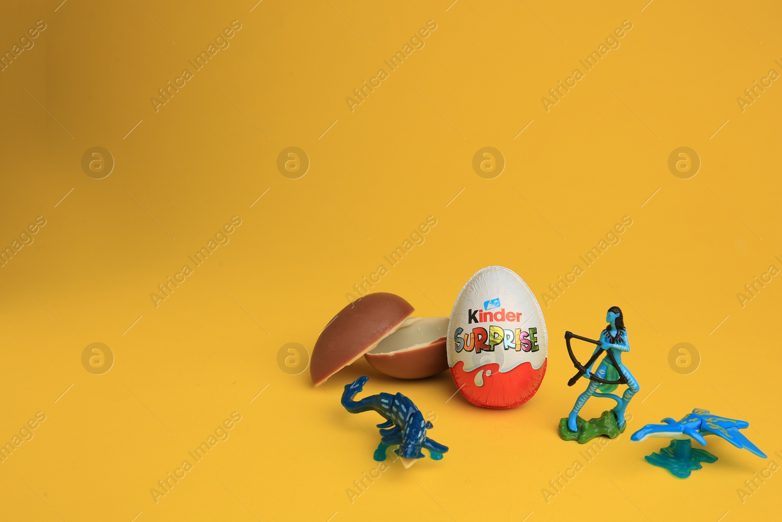 Photo of Sveti Vlas, Bulgaria - July 3, 2023: Kinder Surprise Eggs and toys on yellow background, space for text