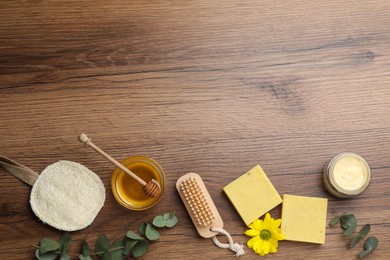 Photo of Flat lay composition with beeswax and cosmetic products on wooden table. Space for text