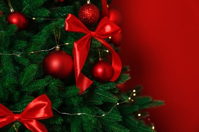 Decorated Christmas tree on red background, closeup