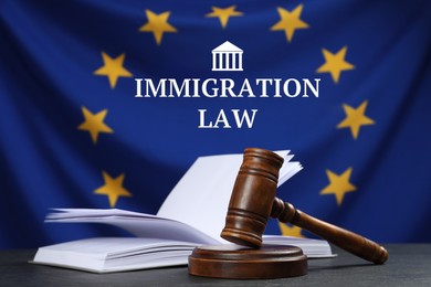 Immigration law. Judge's gavel and open book on black table against flag of European Union