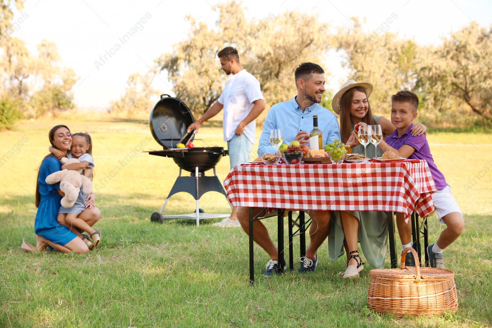 Photo of Happy families with little children having picnic in park