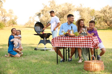 Photo of Happy families with little children having picnic in park