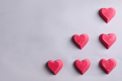 Heart shaped berry ice cubes on grey background, flat lay. Space for text