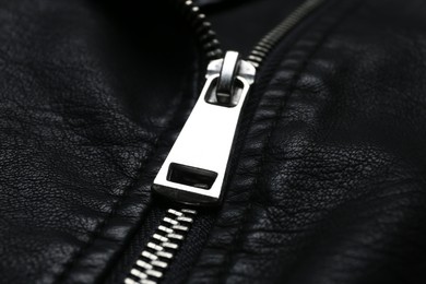 Photo of Closeup view of black leather jacket with zipper as background